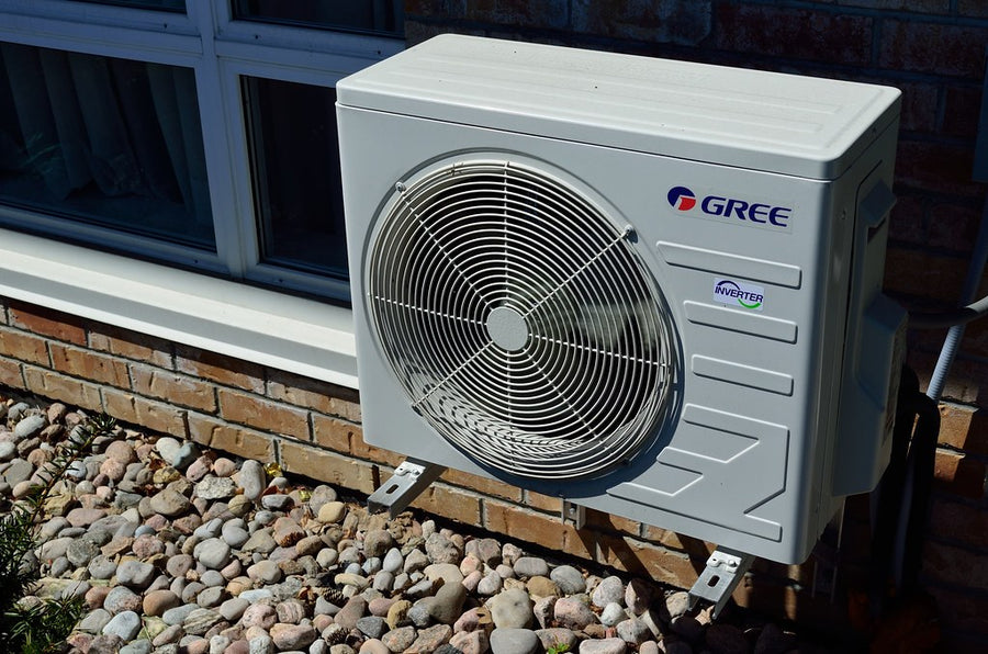 Unidad exterior de aire acondicionado inverter instalada con soportes junto a una ventana
